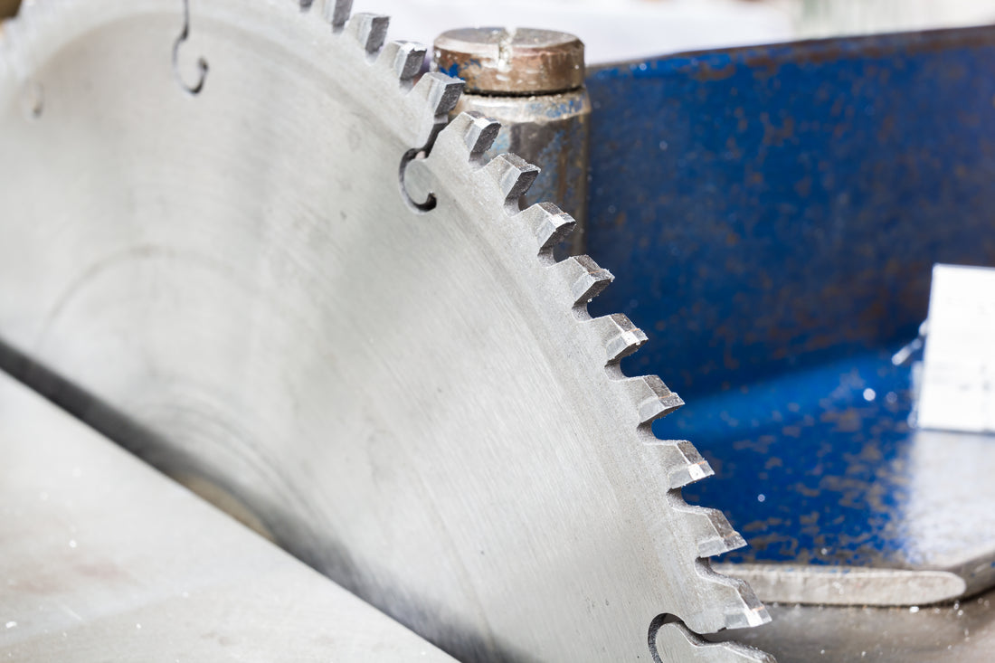 A metal circular saw blade connected to a saw. The teeth look slightly worn down and the saw needs sharpening.