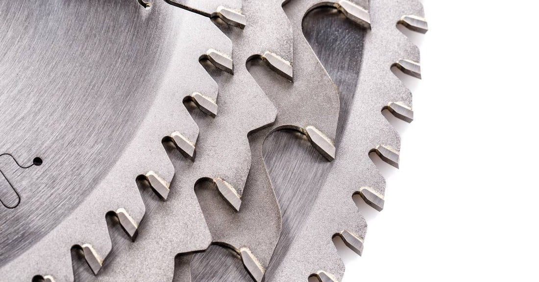 A collection of four different circular saw blades lined up against each other. They have different sizes and shapes of teeth.