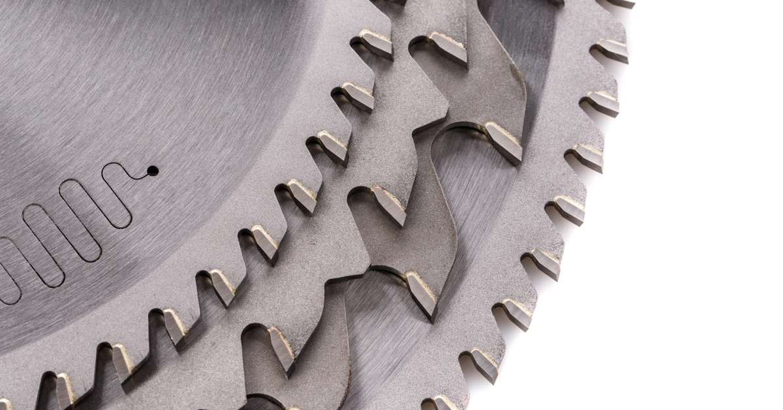 Four circular saw blades lay on top of one another. All four blades have distinct shapes and styles of teeth around the edges.